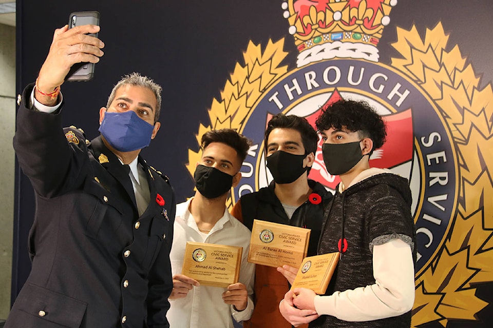 Victoria Police Chief Del Manak snaps a selfie with three Victoria High students who were presented with a civic service award on Friday for their actions in helping someone who was overdosing in a school washroom. (Kendra Crighton/News Staff)