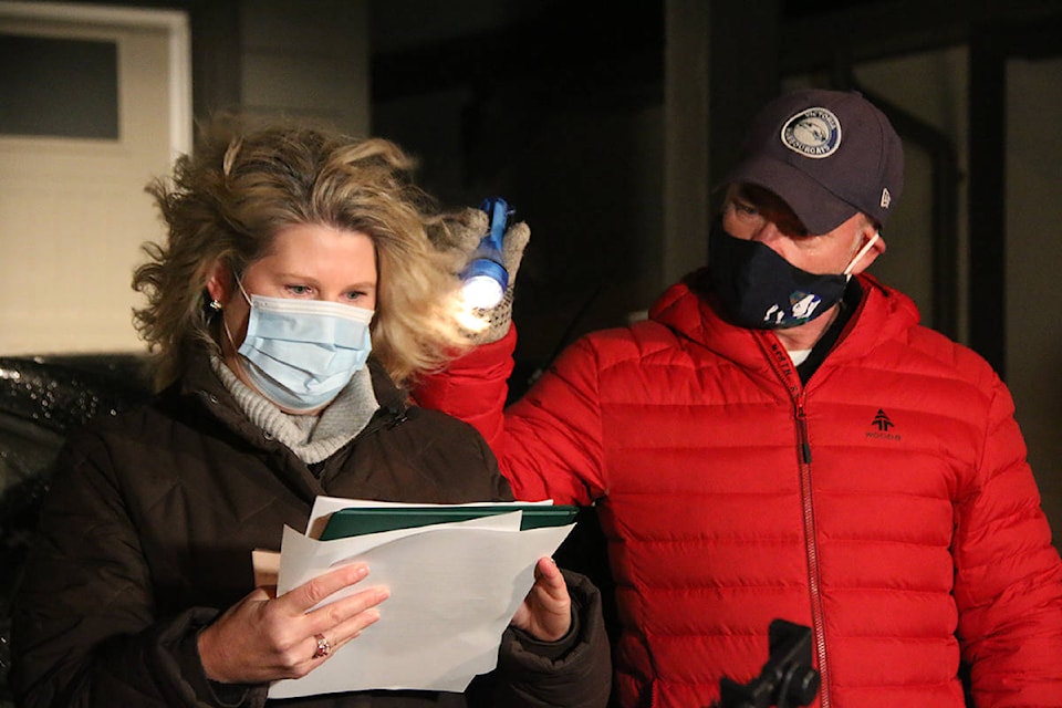 Karen Reilly reads a statement from Kerri Weber’s children at the candlelight vigil. Her husband Mike holds a light for her to see. (Kendra Crighton/News Staff)