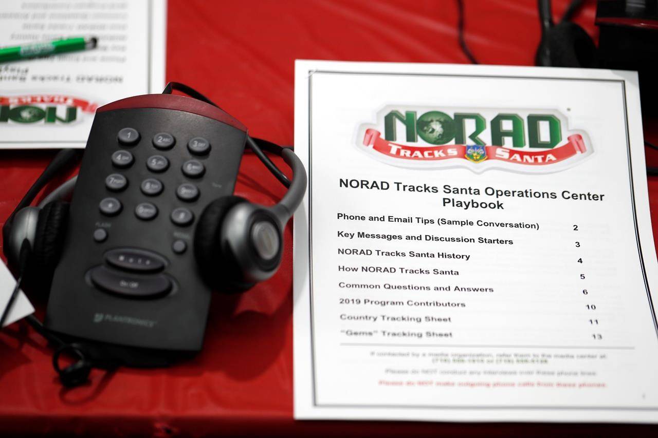FILE - In this Dec. 23, 2019, file photo a playbook sits next to a telephone set up in the NORAD Tracks Santa center at Peterson Air Force Base in Colorado Springs, Colo. The North American Aerospace Defense Command has announced that NORAD will track Santa on December 24, just as it has done for 65 years. But there will be some changes: Not every child will be able to get through to a volunteer at NORADs call center to check on Santas whereabouts, as they have in years before. (AP Photo/David Zalubowski, File)