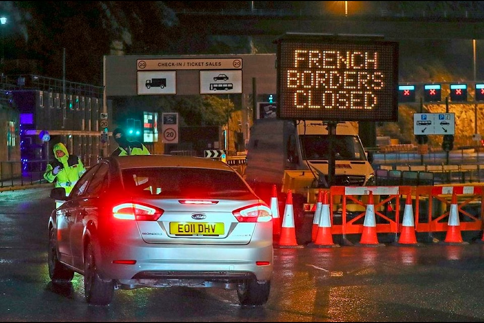 Police and port staff turn away a vehicle from the Port of Dover in Kent, England which has been closed after the French government’s announcement, Monday, Dec. 21, 2020. France banned all travel from the United Kingdom for 48 hours from midnight Sunday, including trucks carrying freight through the tunnel under the English Channel or from the port of Dover on England’s south coast. (Steve Parsons/PA via AP)