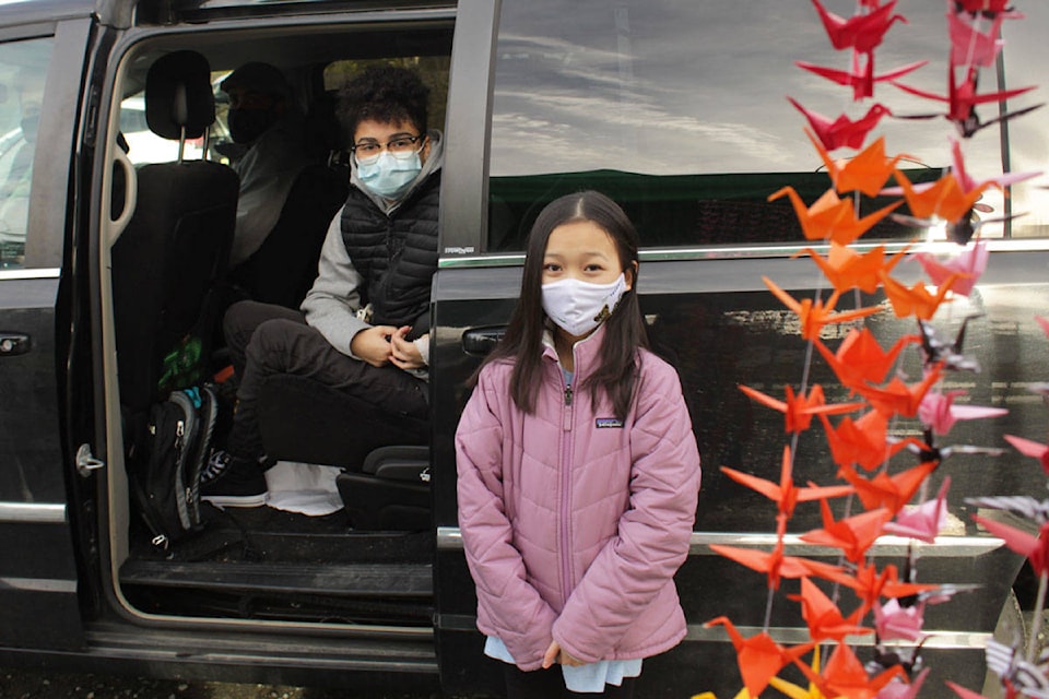 Myla Bui (right) presented a handmade mobile made up of 1,001 paper cranes to Dez Young (left) on Saturday, Jan. 9. (Devon Bidal/News Staff)