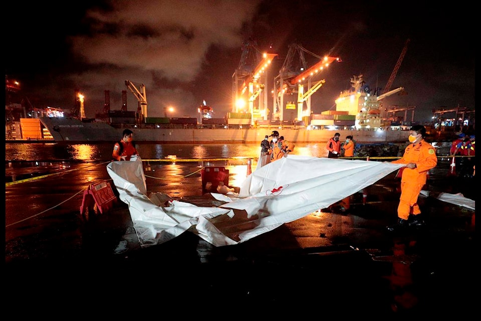 Members of National Search and Rescue Agency (BASARNAS) prepare an area where debris found in the waters where a Sriwijaya Air passenger jet has lost contact with air traffic controllers will be brought to be examined, at Tanjung Priok Port in Jakarta, Indonesia, early Sunday, Jan. 10, 2021. The Boeing 737-500 took off from Jakarta for Pontianak, the capital of West Kalimantan province on Indonesia’s Borneo island with 56 passengers and six crew members onboard, and lost contact with the control tower a few moments later. (AP Photo/Dita Alangkara)
