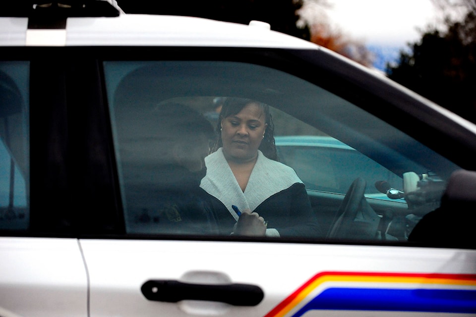 Heather Lucier, a pastor at Kelowna Harvest Fellowship, speaks to an RCMP officer outside of the church on Sunday, Jan. 10. (Michael Rodriguez - Capital News)