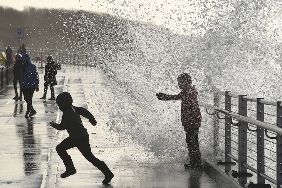 January 13, 2021 - Boys get soaked as they play in waves crashing over the railing along Dallas Road next to the Ogden Point breakwater. High winds created the big waves on an otherwise sunny day. (Don Denton/Black Press Media)