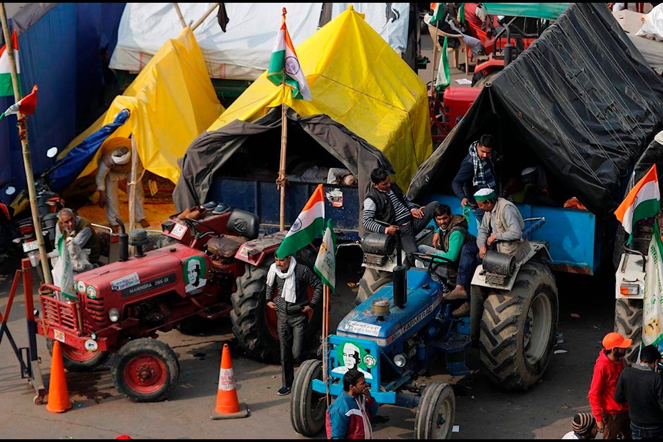Indian farmers sit on their tractor after arriving at the Delhi-Uttar Pradesh border for Tuesday’s tractor rally in New Delhi, India, Monday, Jan. 25, 2021. Thousands of farmers gathered on the borders of Delhi for a massive tractor rally on Tuesday against the three contentious farm laws when India will celebrate its Republic day with a military and cultural parade. The two-month-old old blockade of highways connecting the capital with the country’s north continues as the talks have remained deadlocked with the government refusing to scrap the new agricultural reform laws which the farmers say will benefit large corporations. (AP Photo/Manish Swarup)