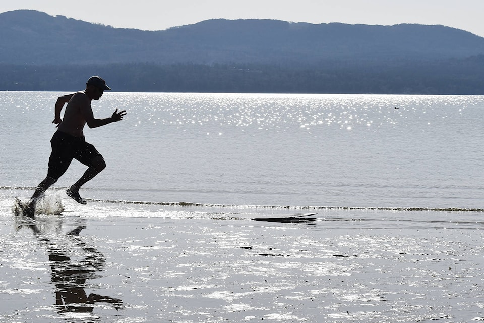Toby Watson races up to his skimboard Monday afternoon at North Saanich’s Patricia Bay. (Wolf Depner/News Staff)