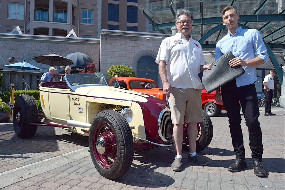 Founding Northwest Deuce Days organizer Al Clark passes along the leather folder he used for years to new event organizer and celebrated Victoria motorcycle builder Jay Donovan. The rebirth of the popular antique and classic car event and its purchase by Destination Greater Victoria was announced on Thursday at the Hotel Grand Pacific. (Kiernan Green/News Staff)