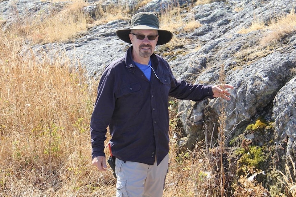 Wylie Thomas with remnants of the tallest camas plant he’s seen, on Kohweechela/Mary Tod Island. (Christine van Reeuwyk/News Staff)