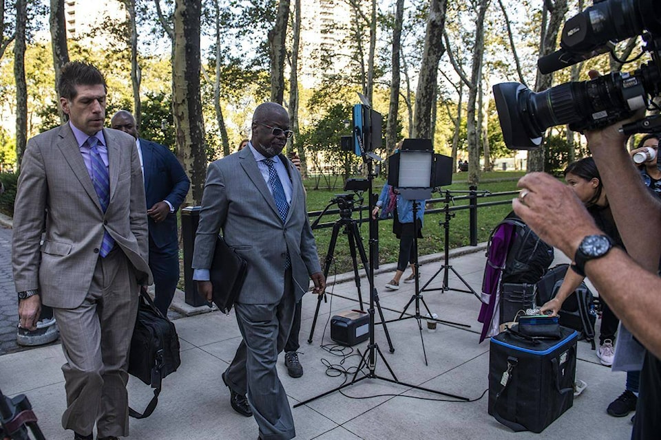 CORRECTS SPELLING OF DEVERAUX - Attorney Deveraux Cannick, representing R&B star R. Kelly, center, arrives at Brooklyn Federal Court House on Monday, Sept. 27, 2021, in New York. The jury resumed deliberations on Monday at the sex trafficking trial of Kelly. The 54-year-old singer of the smash hit “I Believe I Can Fly” has denied any wrongdoing. (AP Photo/Brittainy Newman)