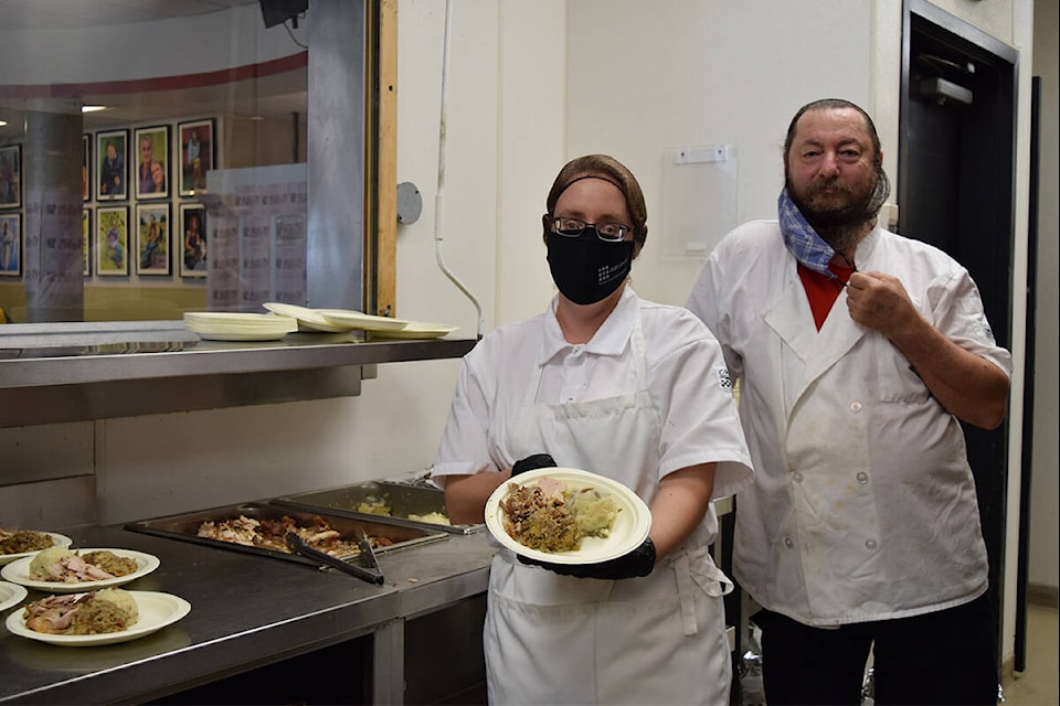 Our Place Society volunteers and cooks Liina Mynttinen and Mike Radovanovic with one of their Thanksgiving meals for their clients. (Kiernan Green/News Staff)