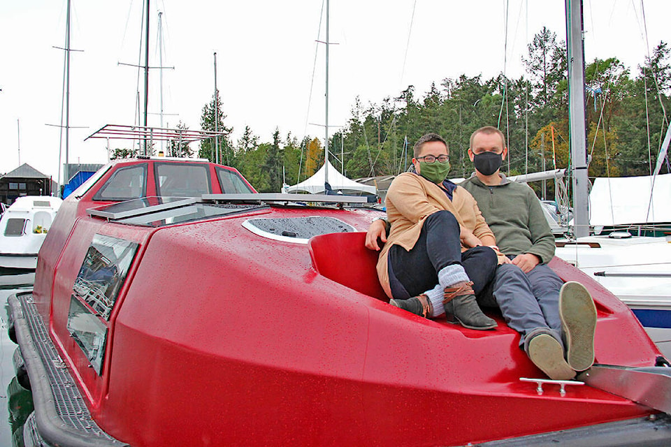 Dani Tate-Stratton (left) and Toryn Sundstrom (right) sit atop their recently acquired BC Ferries lifeboat, a project piece they plan to turn into their home. (Jane Skrypnek/News Staff)