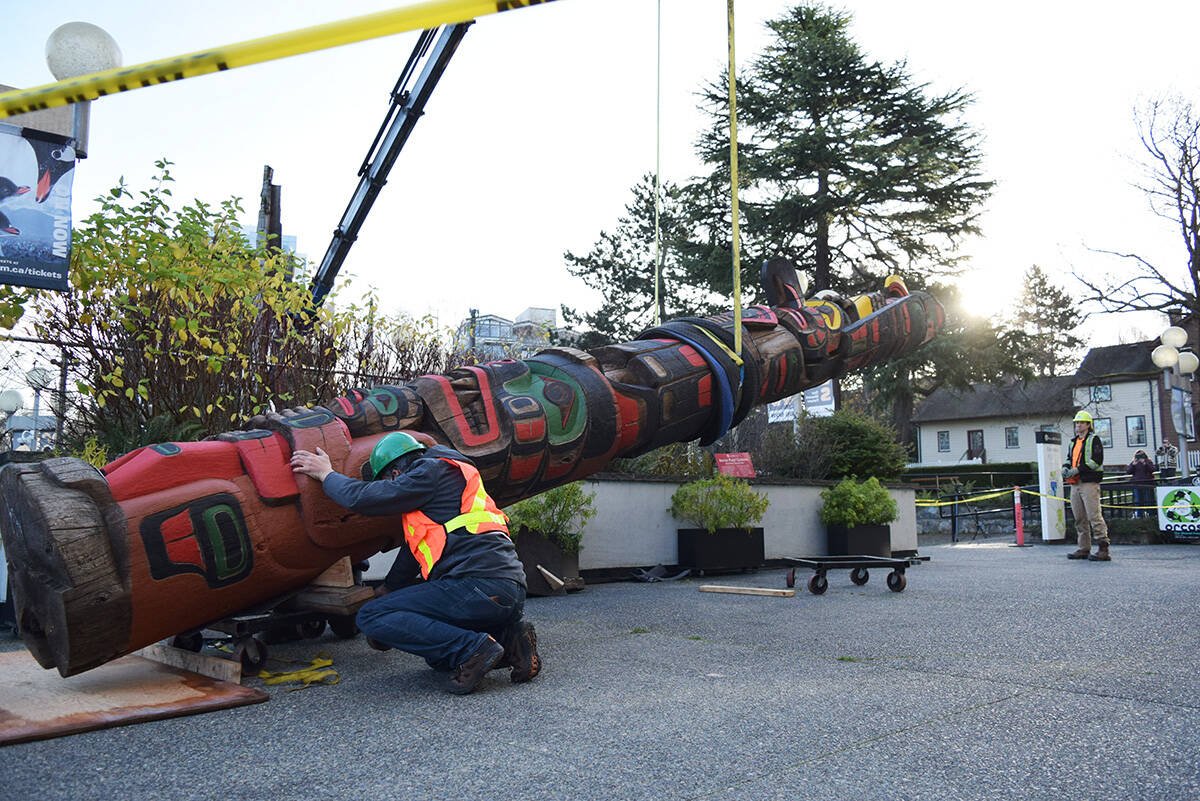 HD Trucking Ltd. staffers prepare to lift Richard Hunts 3,500-pound totem by crane after it was moved out of the Royal BC Museums restoration room. (Kiernan Green/News Staff)