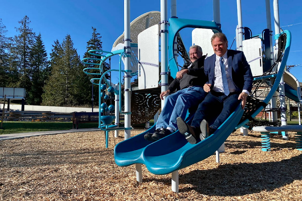 Langford Mayor Stew Young (right) and Coun. Matt Sahlstrom try out the new and improved play structure at Ernhill Park following its official reopening. (Justin Samanski-Langille/News Staff)