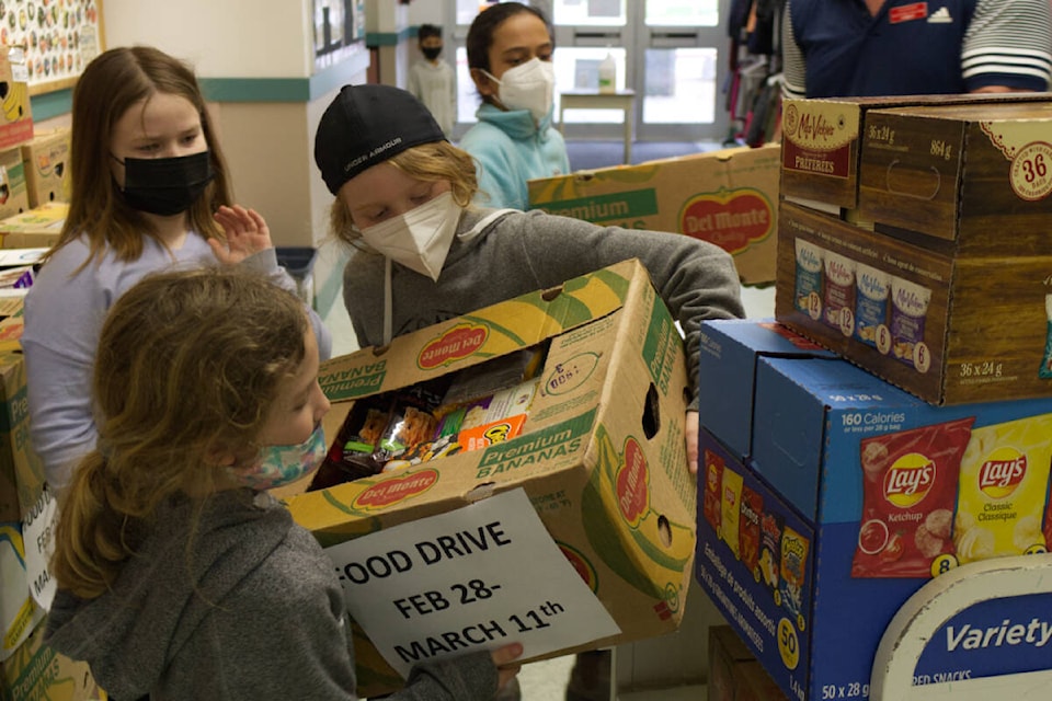 Lakewood elementary students Keely Paty and Sophia Lynch stack a box onto a cart. (Bailey Moreton/News Staff)