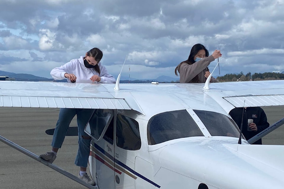 Oak Bay High students Kaelyn Bonner and Katherine Lee do preflight checks at the Victoria Flying Club, ahead of their discovery flight as part of the aviation and design program offered through the Greater Victoria School District. (Tom Aerts/Twitter)