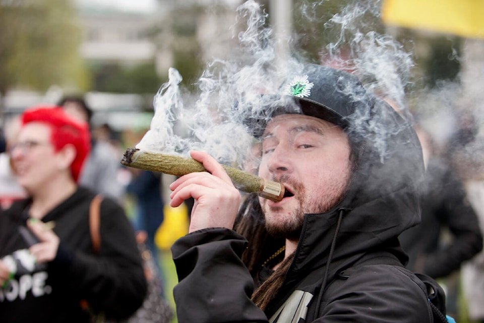 A demonstrator takes a drag out of a comically large joint Wednesday during a 4/20 demonstration at the legislature. (Justin Samanski-Langille/News Staff)