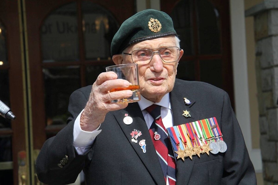 With a sip of scotch John Hillman, 103, celebrates finishing his 103-lap fundraiser for Save the Children. (Christine van Reeuwyk/News Staff)