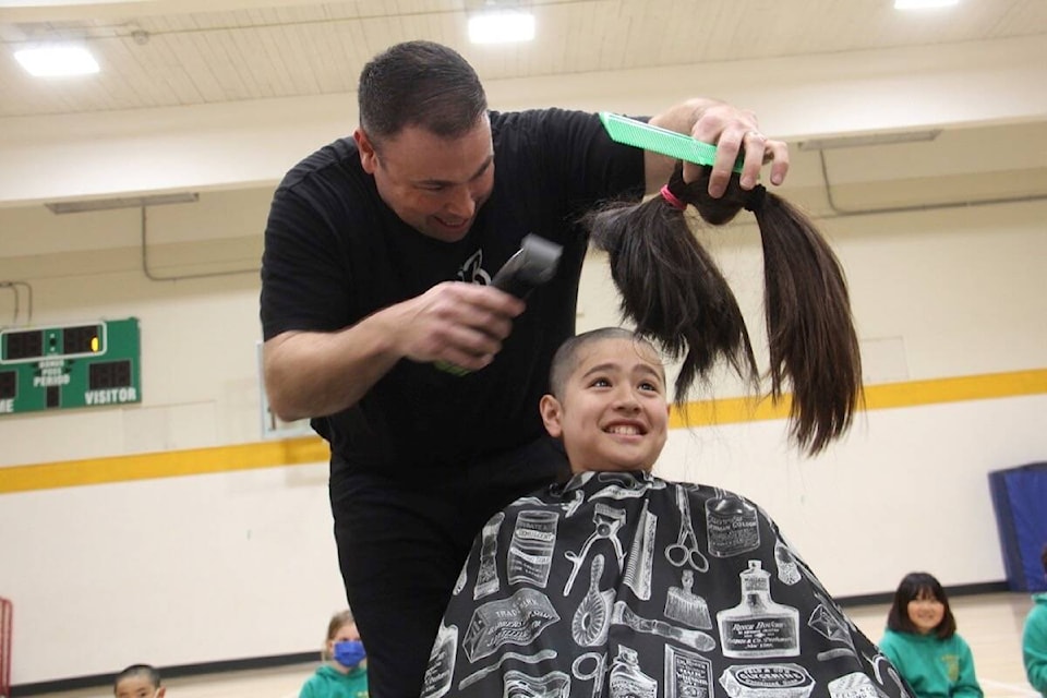 Burt Hill shaves the head of Thomas Joe, a Grade 6 student at St. Patrick’s Elementary School who raised more than his target of $10,000 for cancer research. (Christine van Reeuwyk/News Staff)