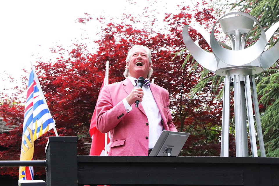 Greater Victoria 55-Plus BC Games 2022 organizing committee chair Michael O’Connor smiles up at Berwick Royal Oak residents looking down on the June 7 proceedings from their balconies. (Don Descoteau/News Staff)