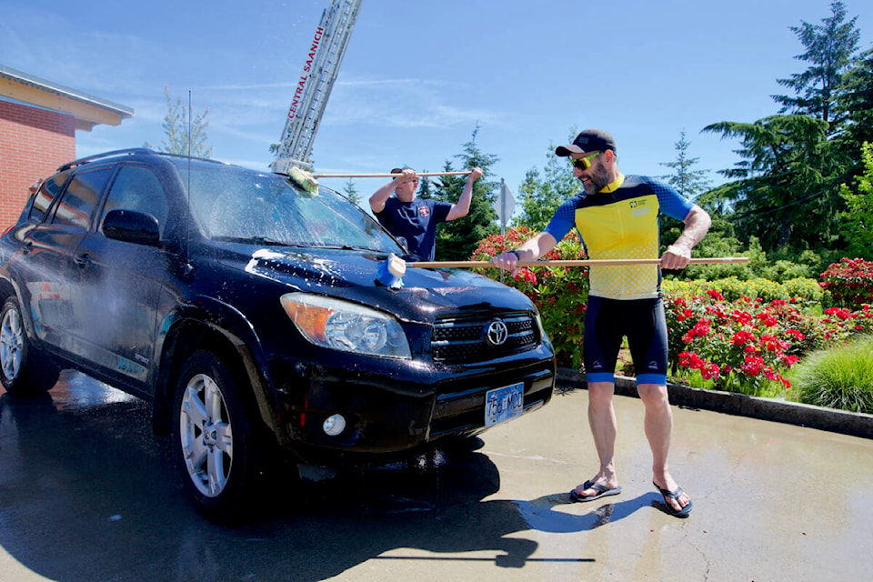 Cpl. Pat Bryant of the Central Saanich Police Service cleans a car Saturday during a fundraiser car wash in support of this year’s Cops for Cancer Tour de Rock fundraiser. (Justin Samanski-Langille/News Staff)
