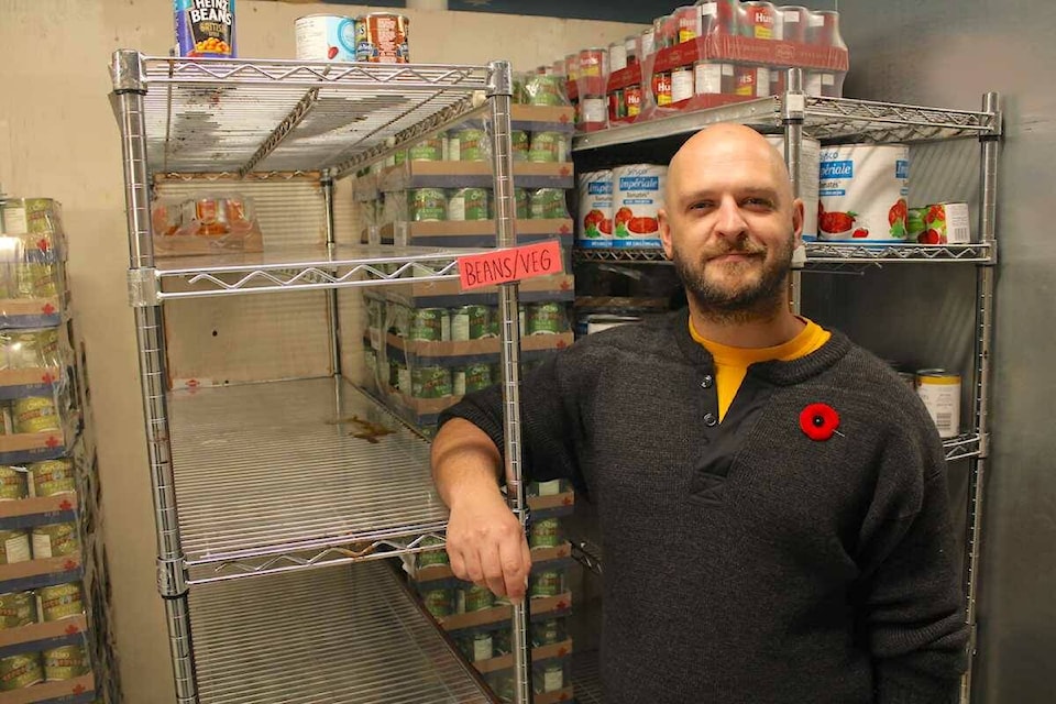 Rainbow Kitchen executive director Patrick Johnstone stands by bare shelves at the meal providing kitchen in Esquimalt on Nov. 3. (Jake Romphf/ News Staff)
