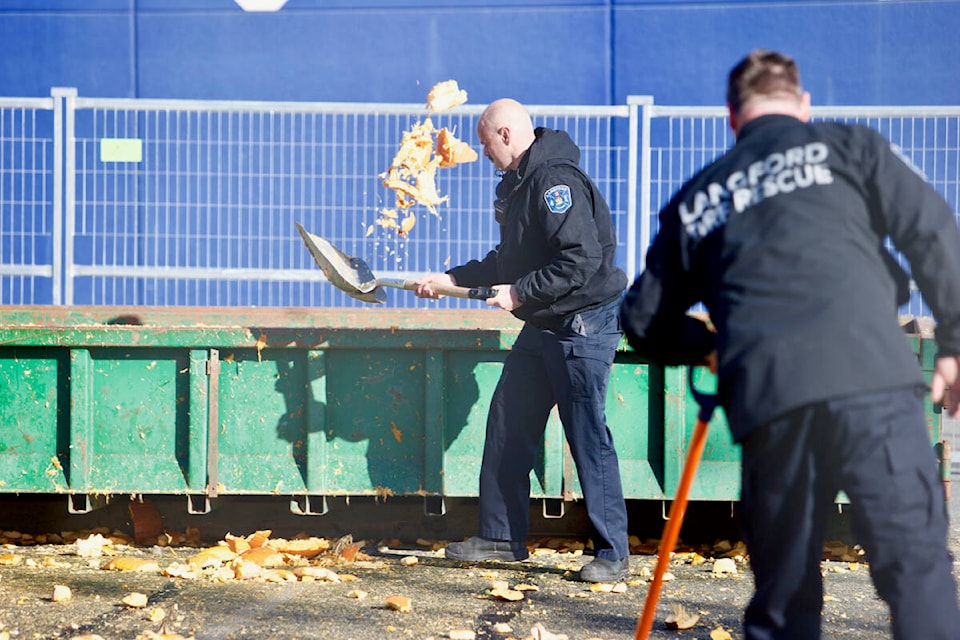 Langford Fire Rescue members shovel pumpkin remains Saturday (Nov. 5) during the department’s annual Pumpkin Smash fundraiser in support of Muscular Dystrophy Canada and the B.C. Professional Firefighters Burn Fund. (Justin Samanski-Langille/News Staff)