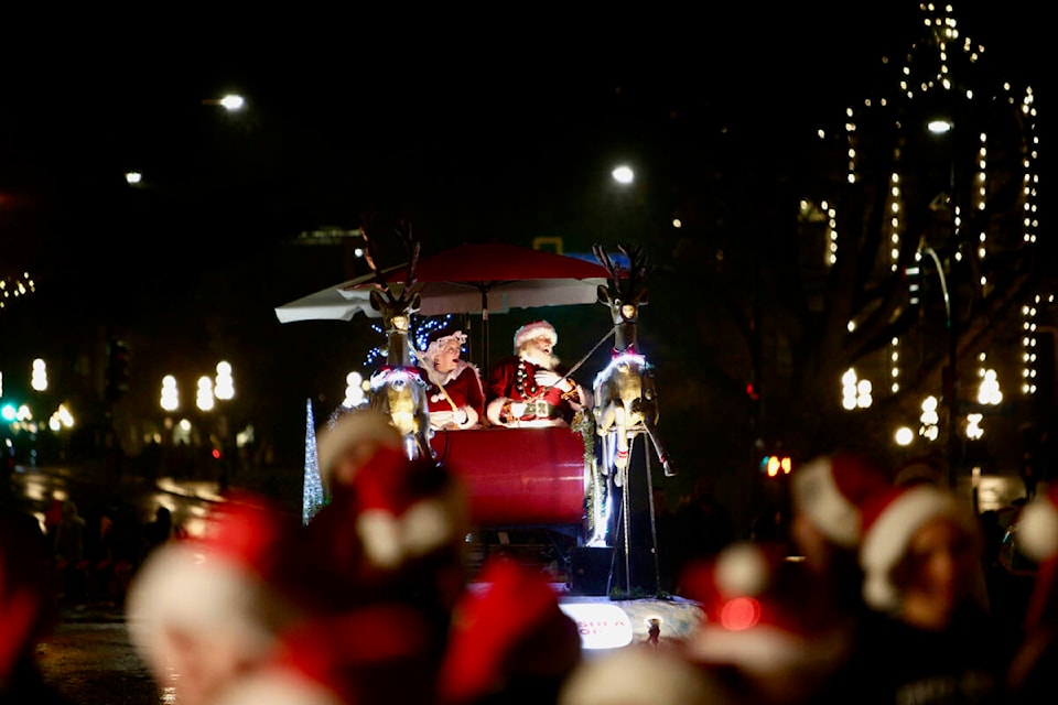 Santa and Mrs. Claus smile and wave to the thousands of people who lined Government and Douglas streets Saturday (Nov. 26) to take in the 40th annual Peninsula Co-op Santa Claus Parade, stopping occasionally to serenade the crowds with a quick Christmas carol. (Justin Samanski-Langille/News Staff)