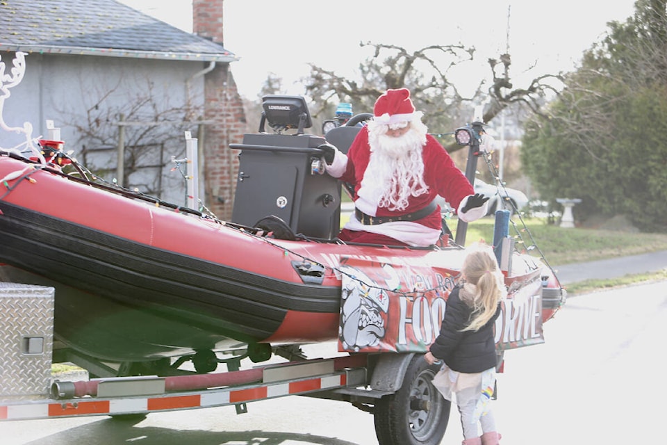 Santa Claus meets with a young View Royal Resident Saturday (Dec. 10) during View Royal Fire Rescue’s annual food drive. (Justin Samanski-Langille/News Staff)