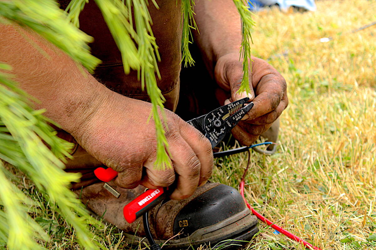 Cody (C.J.) Poole works on the solar-powered cart thats been his home for months. (Jake Romphf/News Staff)