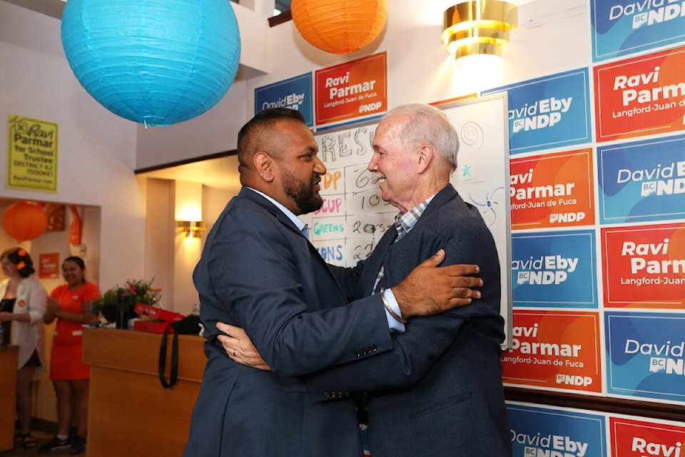 NDP candidate Ravi Parmar embraces former premier and Langford-Juan de Fuca MLA John Horgan Saturday, June 24 at his campaign office after celebrating victory in the byelection for Langford-Juan de Fuca. (Justin Samanski-Langille/News Staff)