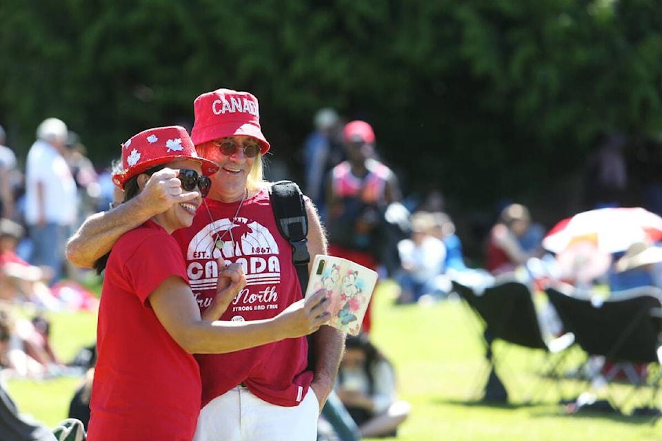 A pair of patriotic-dressed revellers stop for a selfie Saturday, July 1, during Canada Day celebrations at the B.C. legislature in Victoria. (Justin Samanski-Langille/News Staff)