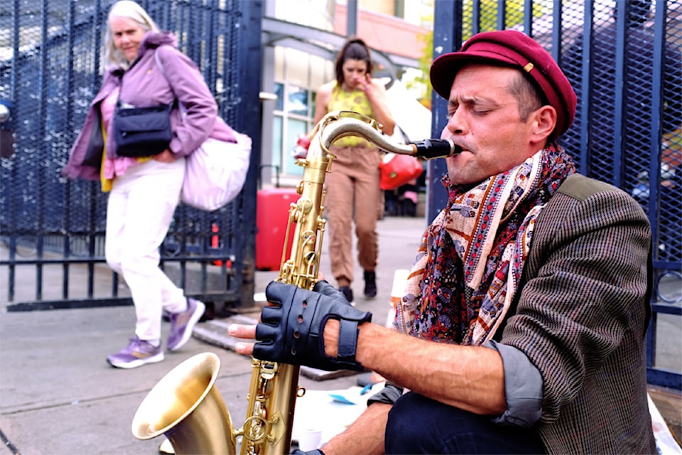 Franco-Canadian Loup Bayle takes out his saxophone and plays a soulful improvisation on the 900 block of Pandora Avenue, on Sept. 23.