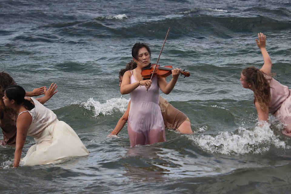 Cindy Kao plays the violin during Kelowna’s Ocean Roaring performance at Tugboat Bay Beach on Aug. 6. (Aaron Hemens/Capital News)