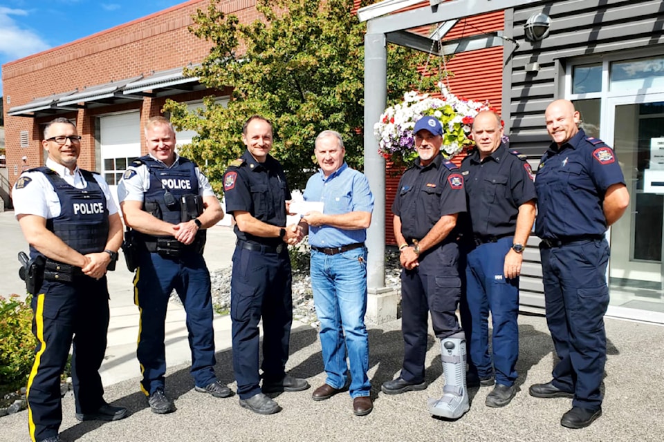 Williams Lake RCMP Insp. Robert Lake, left, Staff Sgt. Brad McKinnon, Williams Lake Fire Department (WLFD) Chief Evan Dean, Williams Lake Stampede Association President Court Smith, WLFD members Derek Sulentich, Kris Wilk and Bill Page gather for a cheque presentation from Smith for the WLFD's charity of choice Muscular Dystrophy Canada. 