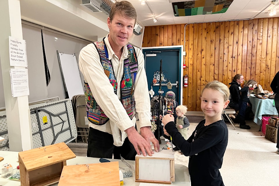 Martin Kruus, left, of Scout Island Nature Centre, helps Riel Tate assemble a bird feeder as one of the Earth-friendly Holiday Event activities on Dec. 6.