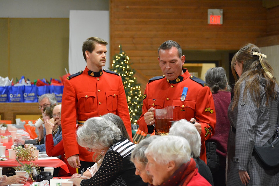 Williams Lake RCMP members Cpl. Dean Perrin and Const. Kyle Stevenson were on hand to serve during the Hub International Christmas Dinner for Seniors held Saturday, Dec. 7 at Sacred Hearth Catholic Hall. 
