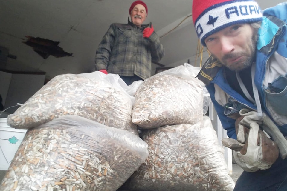 Wilber Saunders, at back, and the butts he collected and will recycle with the help of Oliver Berger, front, waste wise educator. 