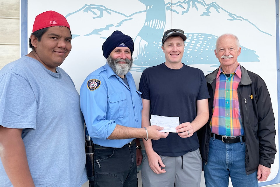Sheldon Phillips, Caribou Ski Source for Sports, left, Bob Sunner, chair of the Williams Lake Community Policing Committee, and Mark Hamm, secretary of the WL Community Policing Committee, right, stand with Chad Handel, winner of first prize for the playoffs hockey pool.