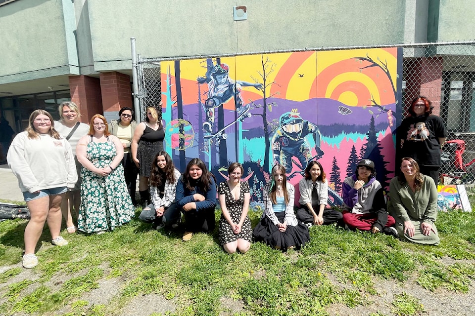 Some of the Lake City Secondary student artists in Siobhan McCambridge's drawing and painting class pose with the mural they designed and created.