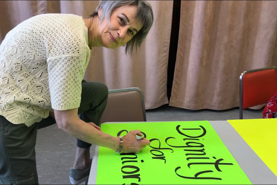 Anna Redekop makes a sign for a Seniors Tin Cup rally June 27 in Williams Lake. 