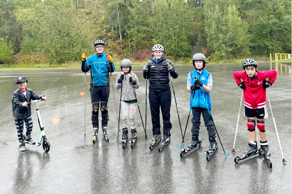 Young nordic skiers and their coaches roller ski in the rain to help prepare for the winter ski season.