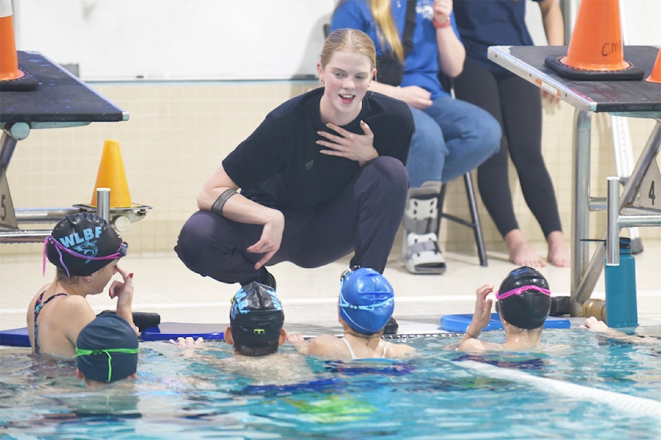Olympic swimmer Ingrid Wilm, centre, gives Blue Fins senior swimmers some tips poolside on Nov. 22, 2024.