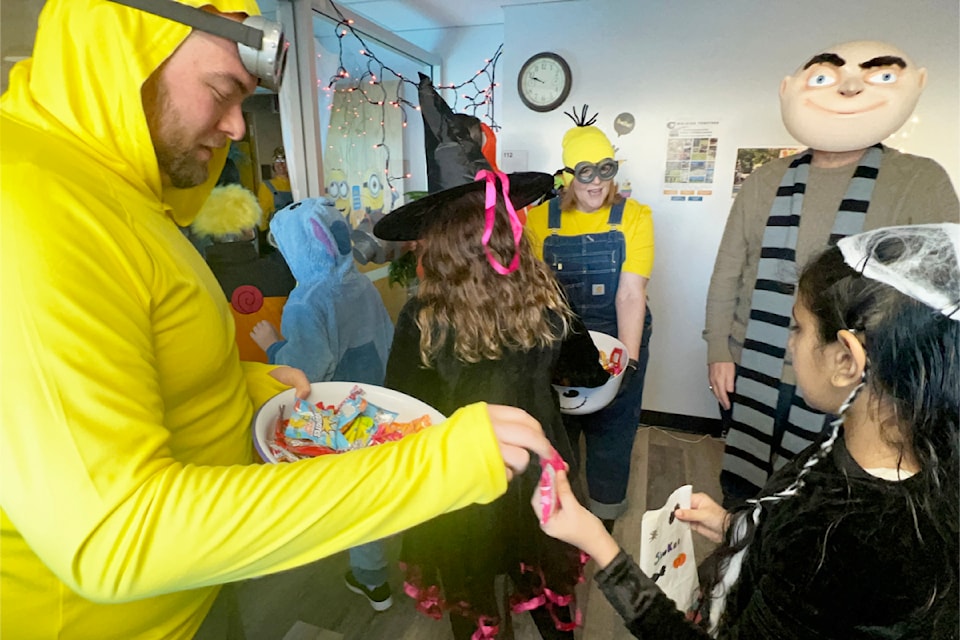 School District 27 administration staff hand out candy to visiting students on Halloween.