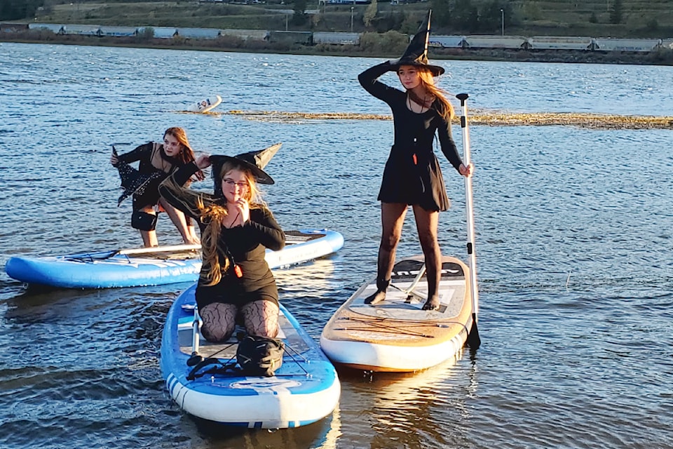 Sisters Jenna, Sharra and Lanna Jessop contend with the wind during the Witches Paddle on Williams Lake Sunday, Oct. 6, 2024. 
