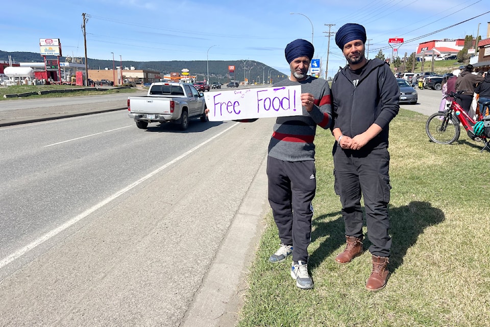 Burhinder Singh and Parhinder Singh stand by the road to promote a free food event to mark Vaisakhi April 13. 