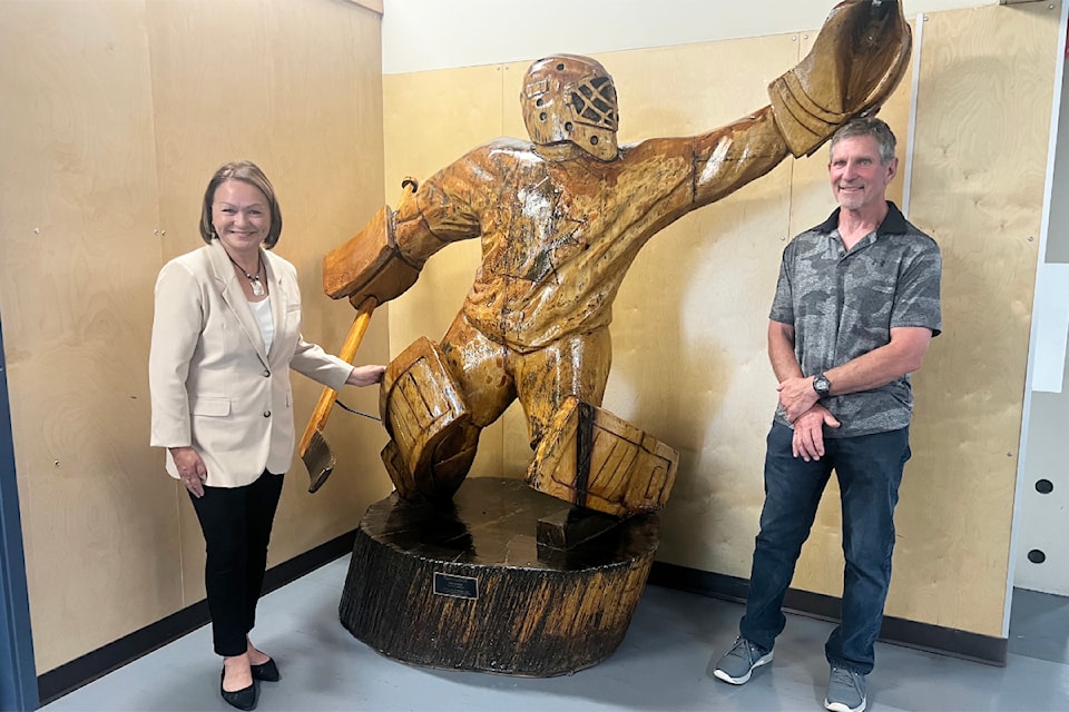 Lynda Price, left, and Jerry Price stand next to the chainsaw carving statue of their son Carey Price.