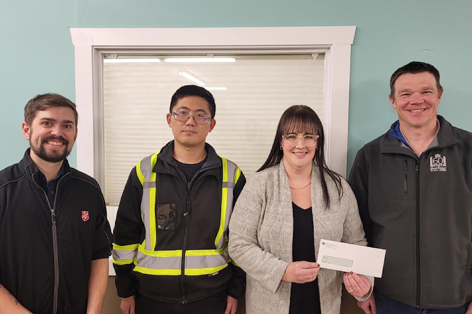 Salvation Army’s Nathanael Hoeft (Corps officer), left, and Tamara Robinson ( Community Ministries Director) third from left accept a donation from Sandor Rui Yang and Sandor Buchi from the Williams Lake Plywood plant, a division of West Fraser Mills Ltd. in the amount of $10,000.