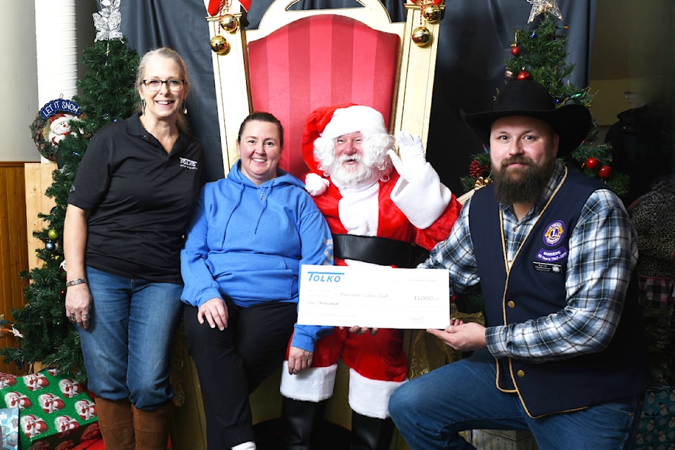 Breakfast with Santa Tolko volunteers and helpers Rita Mosdell, left, and Michelle Evdokimoff donate a cheque to support the event accepted by Santa Claus, Lions Club member Jim Biller, and Kevin Thaleimer, event organizer for the Lions. 