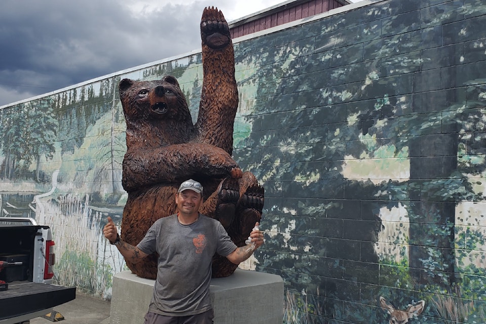 Spirit Carver Dean with his latest sculpture being installed beside Sam's Restaurant in Williams Lake. 