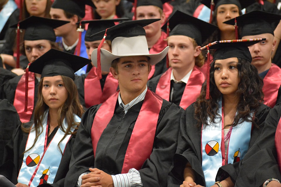 2025 Williams Lake Secondary School grad Sam Holmes, centre, dons a cowboy hat and a grad cap during the ceremony Friday, June 13 at the Cariboo Memorial Recreation Complex. 